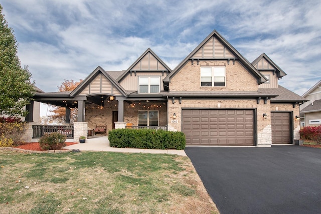 craftsman house featuring a front yard, a porch, and a garage