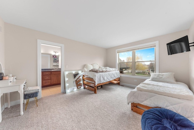 bedroom with sink, light carpet, and ensuite bath