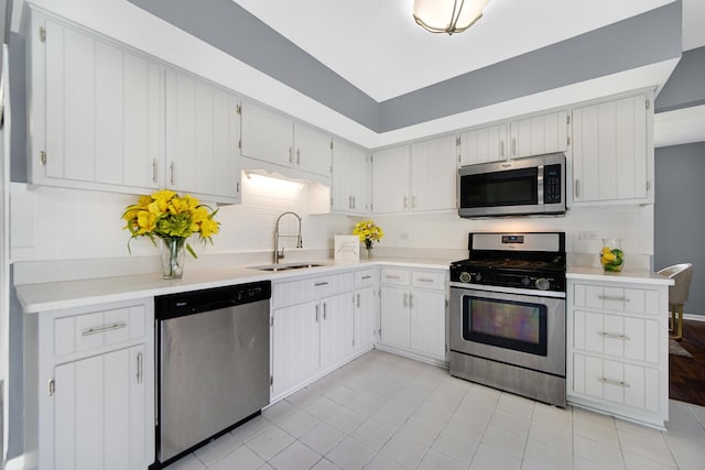 kitchen with backsplash, sink, white cabinets, and stainless steel appliances