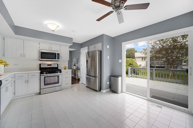 kitchen with white cabinetry, light tile patterned floors, stainless steel appliances, and ceiling fan