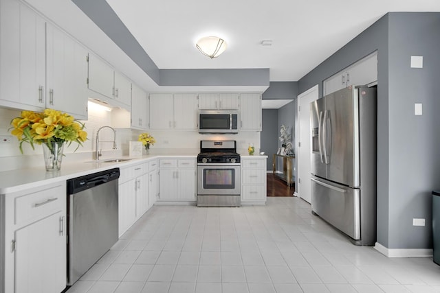 kitchen featuring backsplash, stainless steel appliances, white cabinetry, and sink