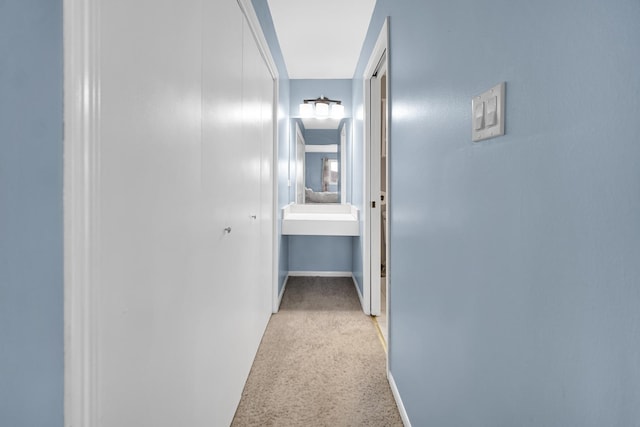 hall featuring light colored carpet