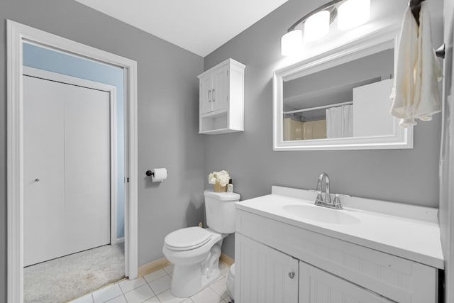 bathroom with tile patterned flooring, vanity, toilet, and walk in shower