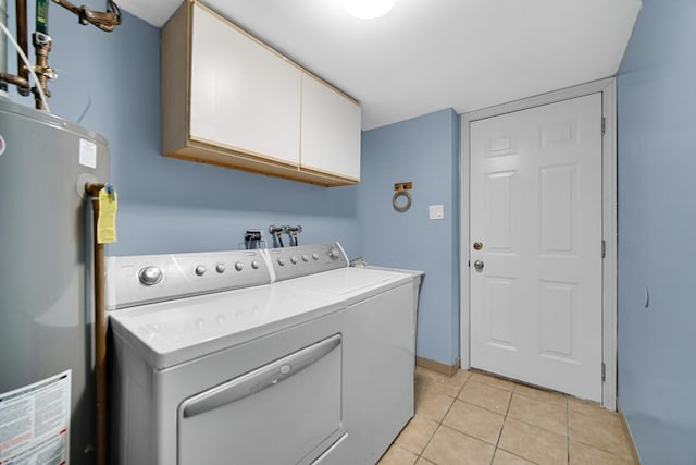 laundry area featuring cabinets, washing machine and clothes dryer, light tile patterned floors, and water heater