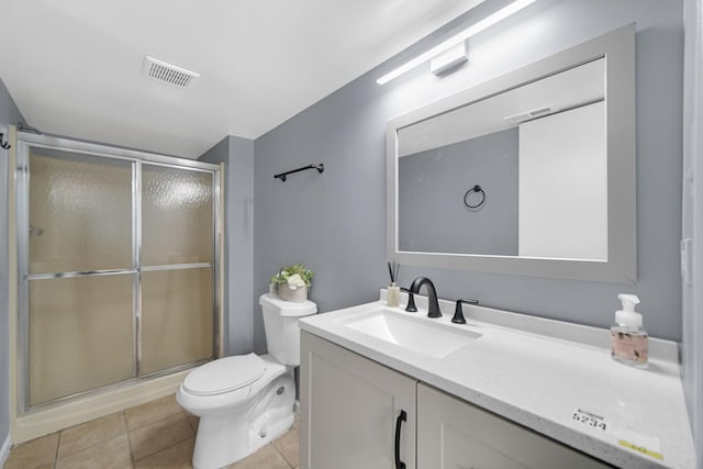 bathroom featuring tile patterned flooring, vanity, toilet, and an enclosed shower