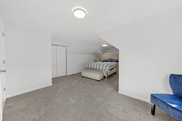 carpeted bedroom featuring a closet and lofted ceiling