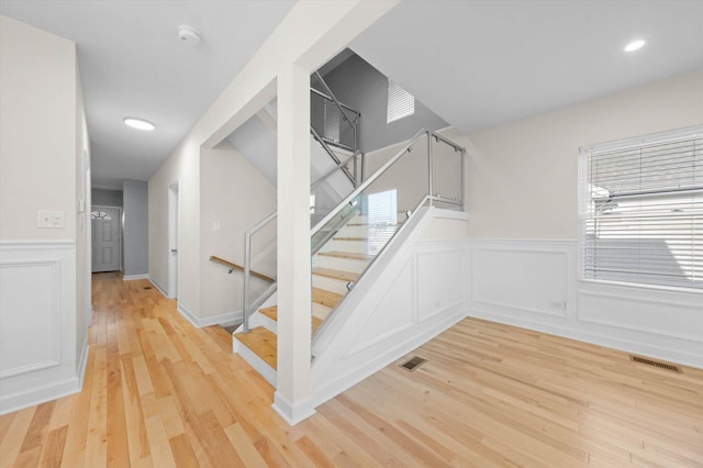 staircase featuring wood-type flooring and a healthy amount of sunlight