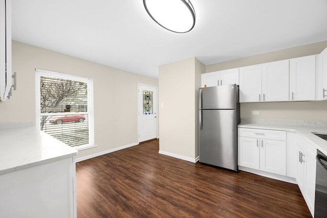 kitchen featuring dark wood-type flooring, stainless steel fridge, light stone countertops, black dishwasher, and white cabinetry