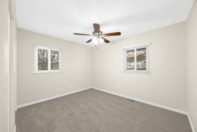 empty room with ceiling fan and carpet floors