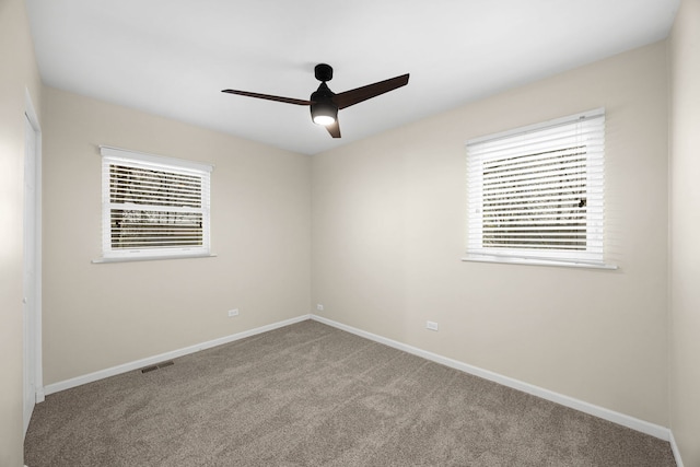 carpeted spare room with ceiling fan