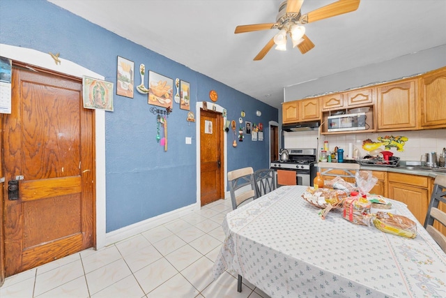 kitchen with light tile patterned floors, backsplash, stainless steel appliances, and ceiling fan