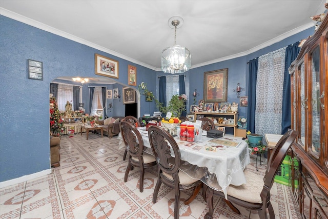 dining space with ornamental molding and a chandelier