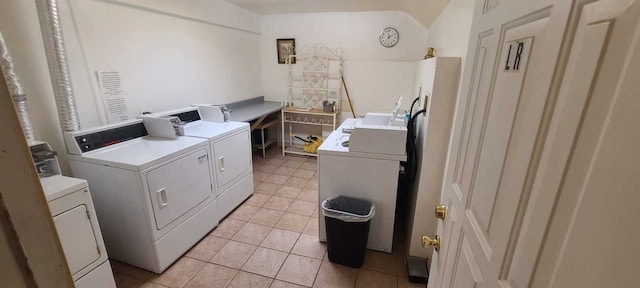 clothes washing area featuring washer and clothes dryer and light tile patterned floors