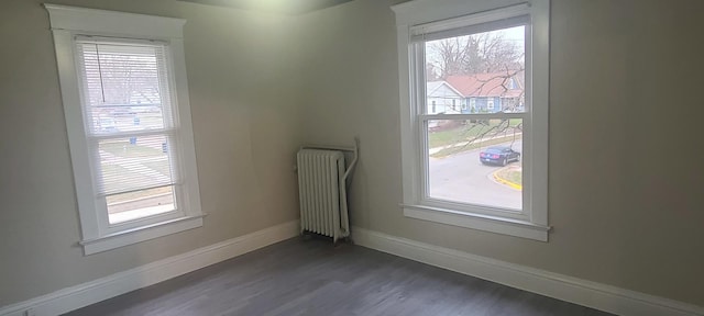 empty room with radiator and dark wood-type flooring