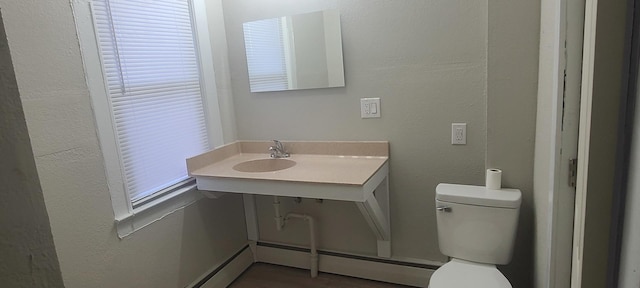 bathroom with a baseboard radiator, toilet, and sink