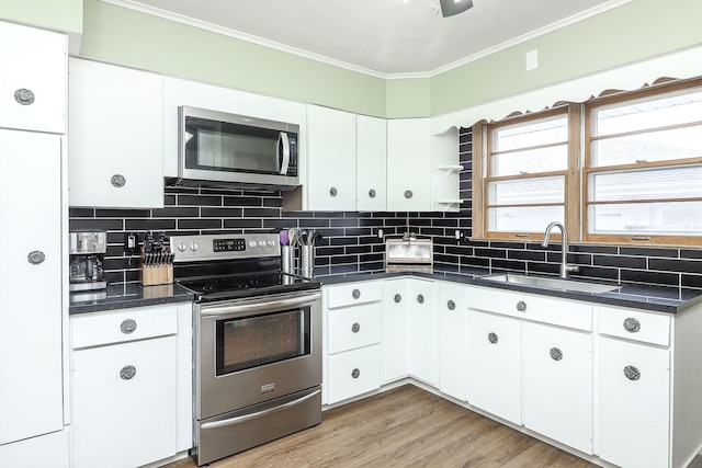 kitchen with decorative backsplash, appliances with stainless steel finishes, white cabinetry, and sink