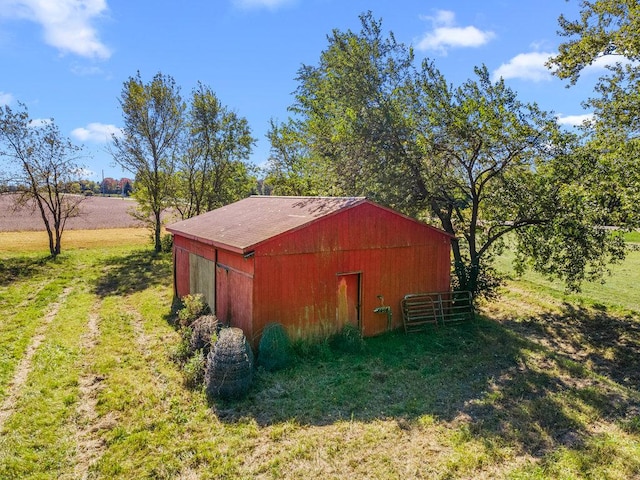 view of outbuilding featuring a lawn and a rural view