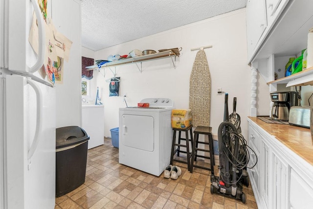 laundry room with washing machine and dryer and a textured ceiling