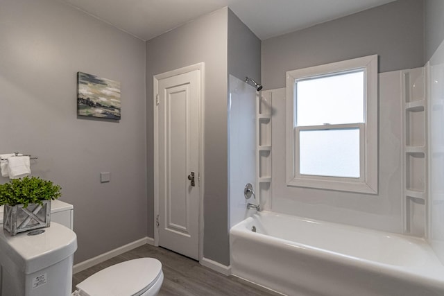 bathroom with toilet, hardwood / wood-style floors, and bathing tub / shower combination