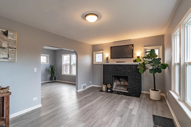 living room with hardwood / wood-style flooring and a brick fireplace