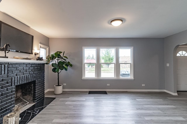 living room featuring hardwood / wood-style floors and a brick fireplace