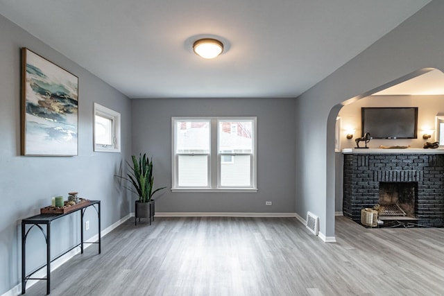 living room featuring hardwood / wood-style flooring and a brick fireplace