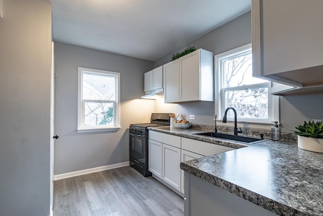 kitchen with white cabinets, sink, black range with gas cooktop, and light wood-type flooring