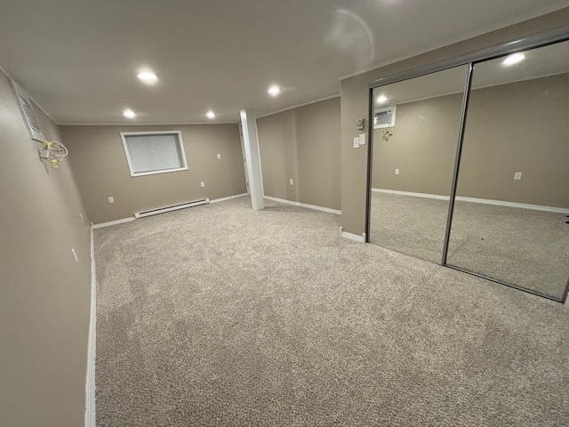 basement featuring a wall unit AC, carpet, and a baseboard heating unit