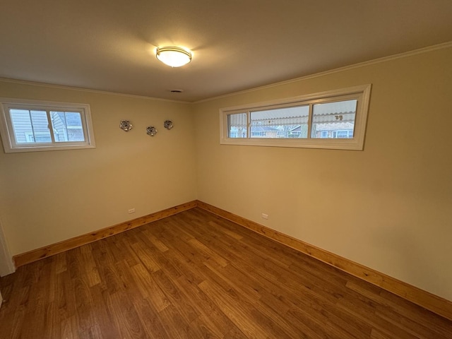 empty room featuring wood-type flooring and crown molding