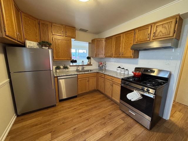 kitchen with decorative backsplash, sink, light hardwood / wood-style floors, and appliances with stainless steel finishes