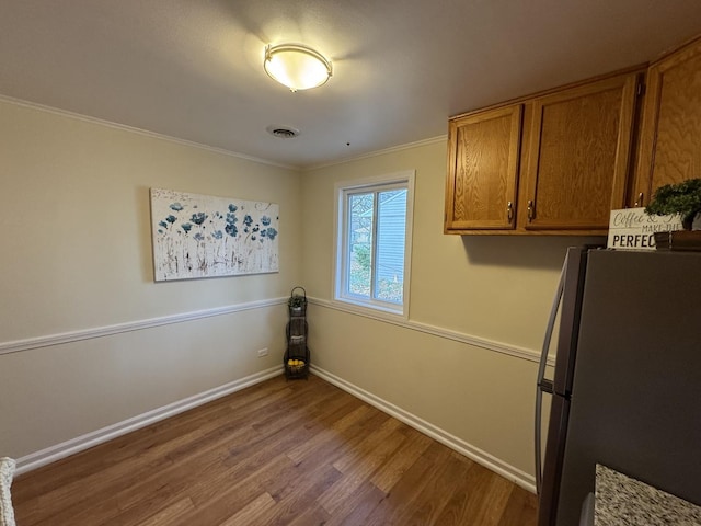 laundry room with crown molding and hardwood / wood-style floors