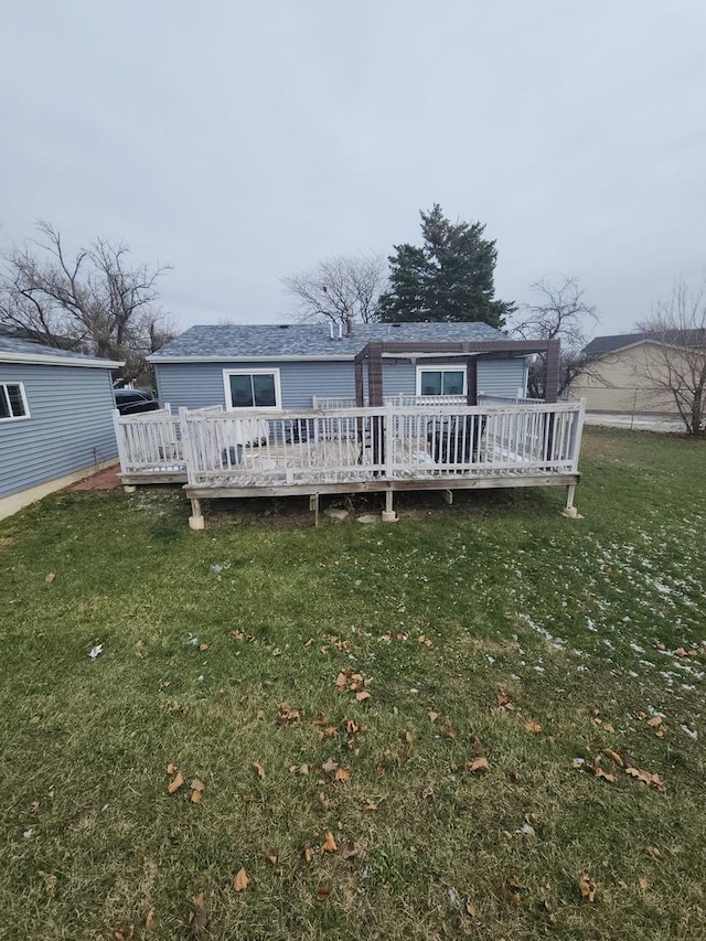 back of house featuring a lawn and a wooden deck