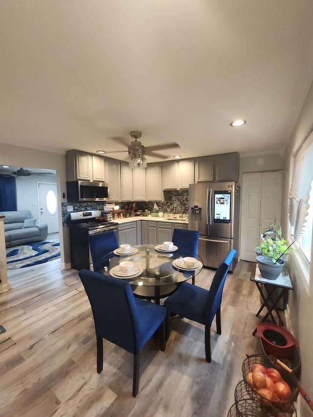 dining area with ceiling fan and light hardwood / wood-style floors