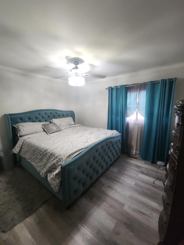 bedroom featuring hardwood / wood-style floors, ceiling fan, and crown molding