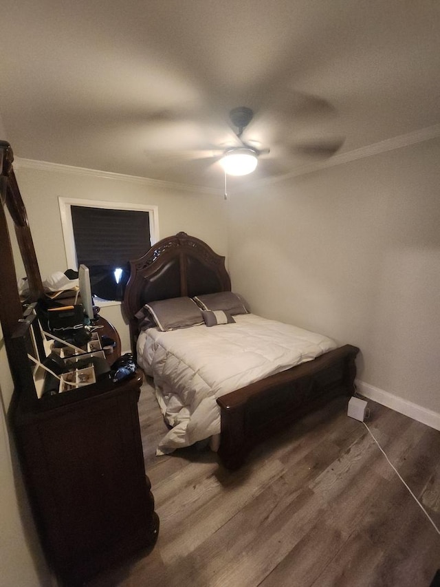 bedroom with ceiling fan, ornamental molding, and dark wood-type flooring