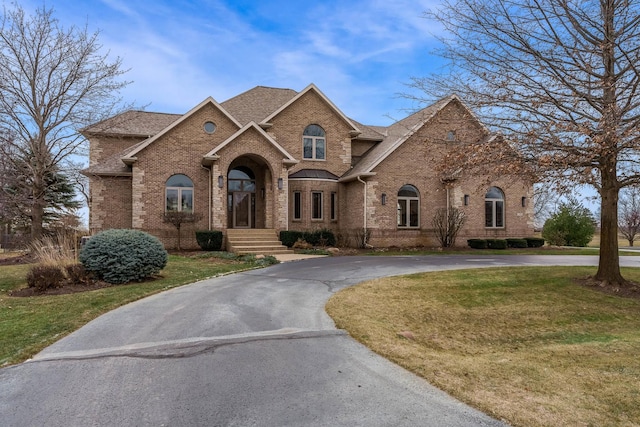 french country inspired facade with a front lawn