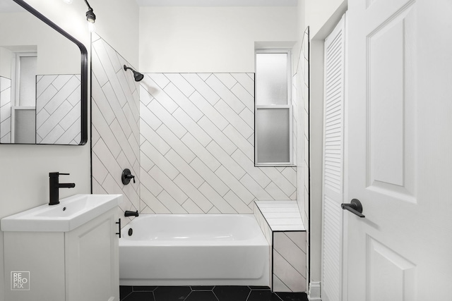 bathroom with tile patterned floors, vanity, and tiled shower / bath