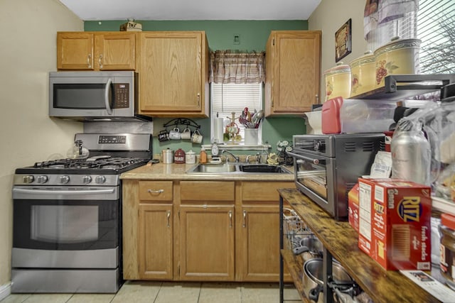 kitchen featuring sink, stainless steel appliances, and light tile patterned flooring