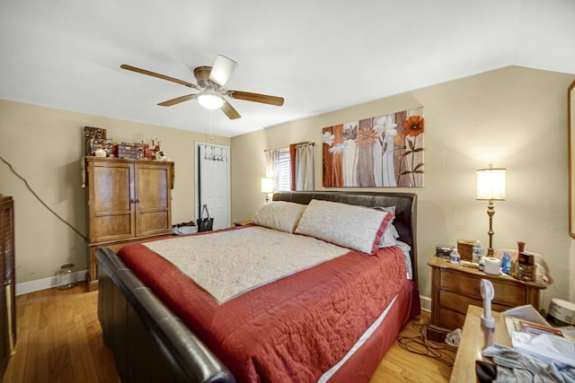 bedroom featuring light hardwood / wood-style floors, vaulted ceiling, and ceiling fan