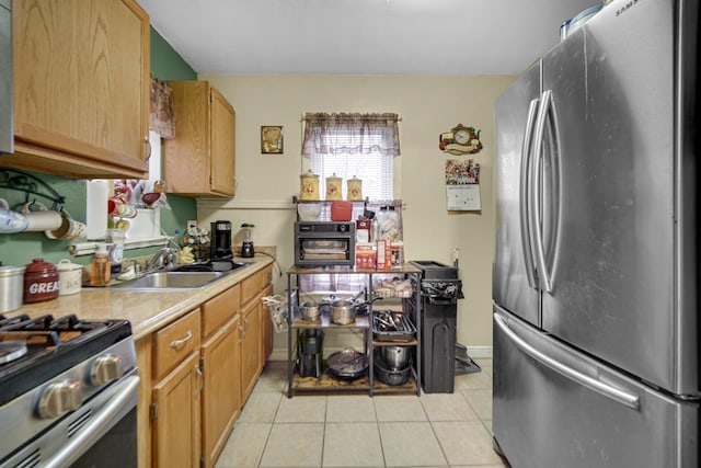 kitchen featuring light tile patterned floors, stainless steel refrigerator, and sink