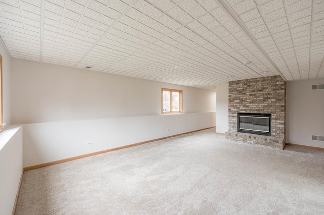 unfurnished living room with carpet and a brick fireplace