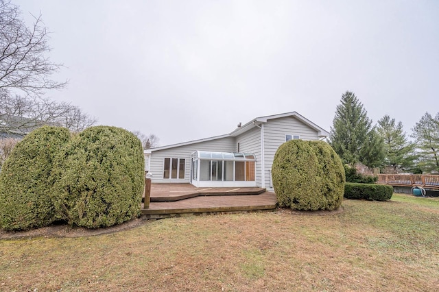 view of side of home with a yard and a wooden deck