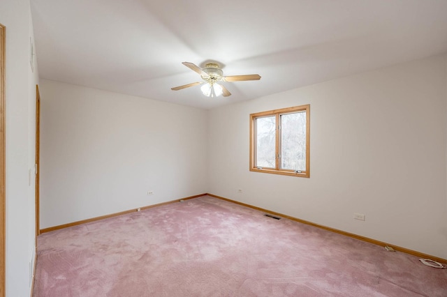 spare room featuring light carpet and ceiling fan