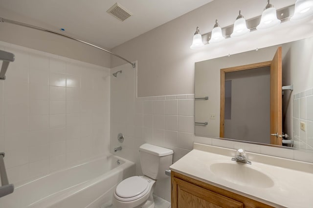 full bathroom with vanity, toilet, tile walls, and tiled shower / bath