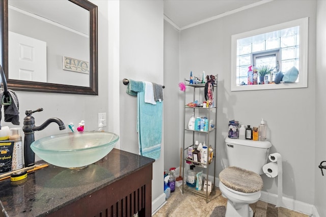 bathroom with vanity, ornamental molding, and toilet