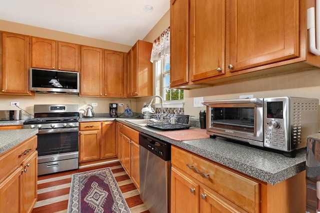 kitchen with sink, light wood-type flooring, and appliances with stainless steel finishes