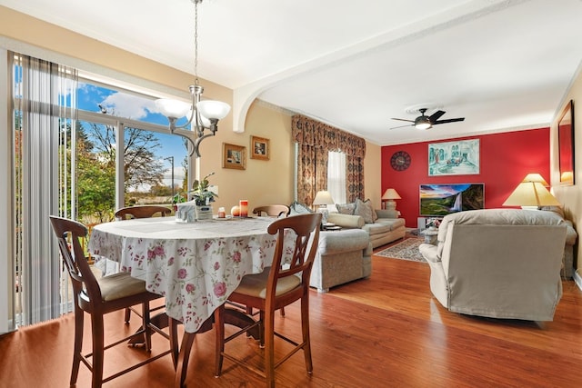 dining space featuring ceiling fan with notable chandelier and wood-type flooring