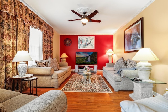 living room featuring crown molding, wood-type flooring, and ceiling fan