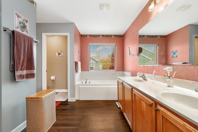 bathroom featuring hardwood / wood-style flooring, vanity, and a bathing tub