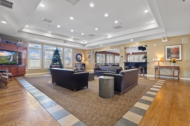 living room featuring a tray ceiling and hardwood / wood-style flooring